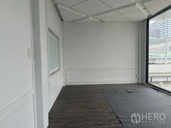 Retail Space for rent in Bang Rak, Bangkok - Open retail area with floor‑to‑ceiling glass and wood floors overlooking terrace.
