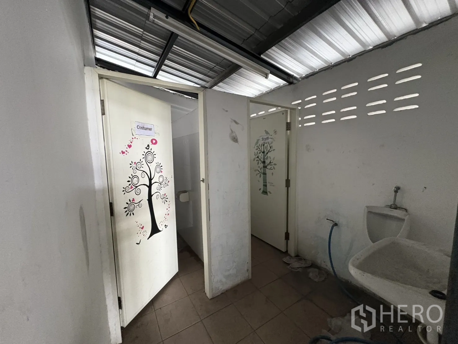 Warehouse for rent in Mueang Samut Prakan, Samut Prakan - External restroom block with multiple cubicles and basin under a ventilated roof.