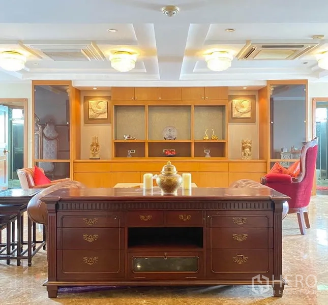 Condominium for rent in Khlong Toei, Bangkok - Living area featuring coffered ceiling lights and custom built-in shelving.