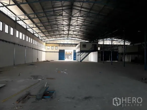 货栈 出租在Mueang Samut Prakan, Samut Prakan - 开放式仓库，前方蓝色装卸大门、侧墙高窗与夹层办公室