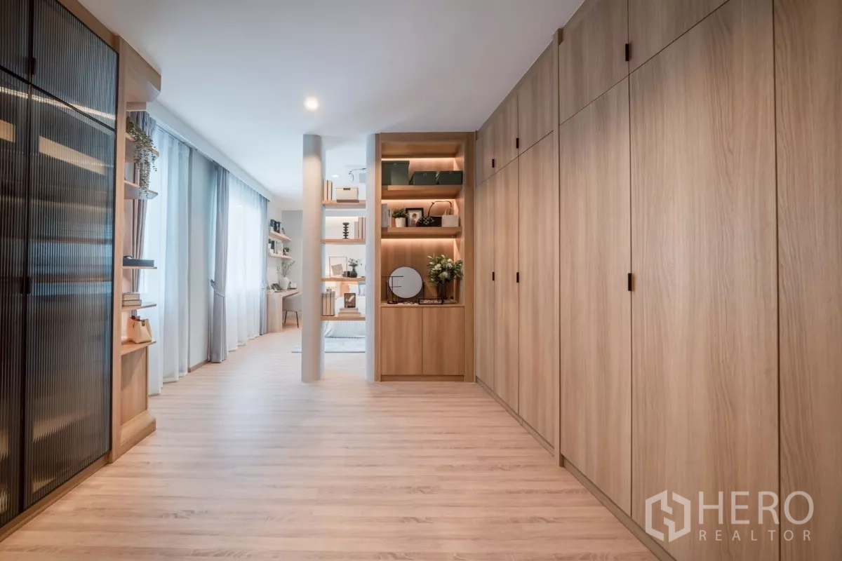 Detached House for rent in Saphan Sung, Bangkok - Walk‑in wardrobe corridor with full‑height built‑in cabinets and display shelving.