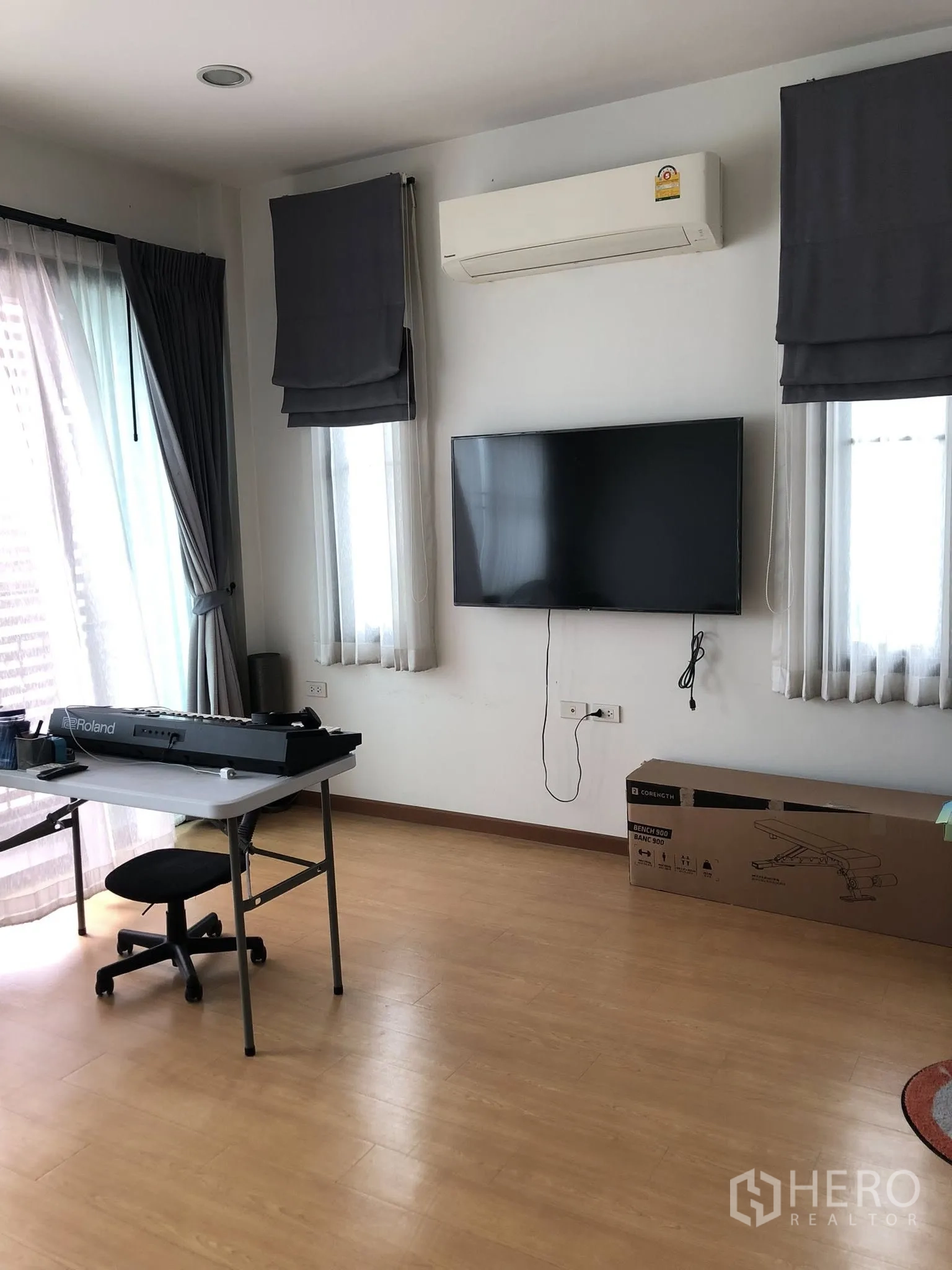 Townhouse for sale in Phra Khanong, Bangkok - Bedroom with wall-mounted TV, split air-conditioner and work desk with natural light.