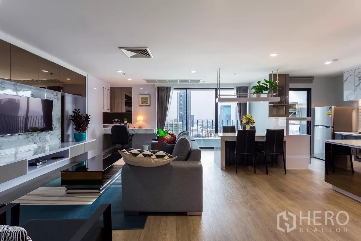 Condominium for rent or sale in Watthana, Bangkok - Wide view of open-plan lounge and kitchen with dining table and panoramic city outlook.