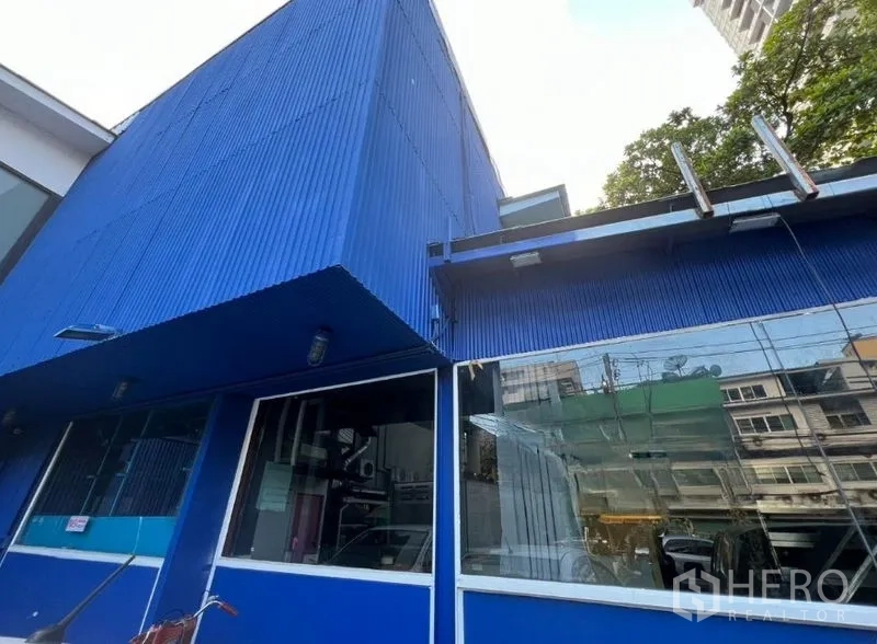 零售空间 出租在Watthana, Bangkok - 蓝色波纹外墙与镜面橱窗的斜角外观