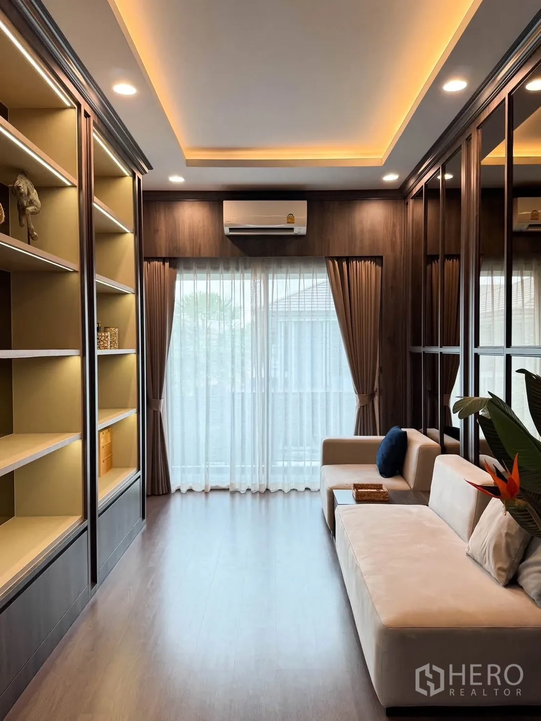 Detached House for rent in Bang Kapi, Bangkok - Upstairs family room with illuminated shelves, sofa, and recessed ceiling lights.