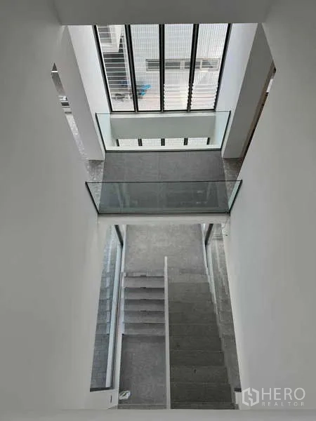 Home Office for rent or sale - Stairwell with full-height glazing illuminating grey steps.