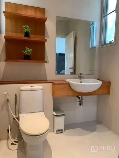 Detached House for rent in Lat Krabang, Bangkok - Guest bathroom featuring wall shelves, vanity mirror and white basin.