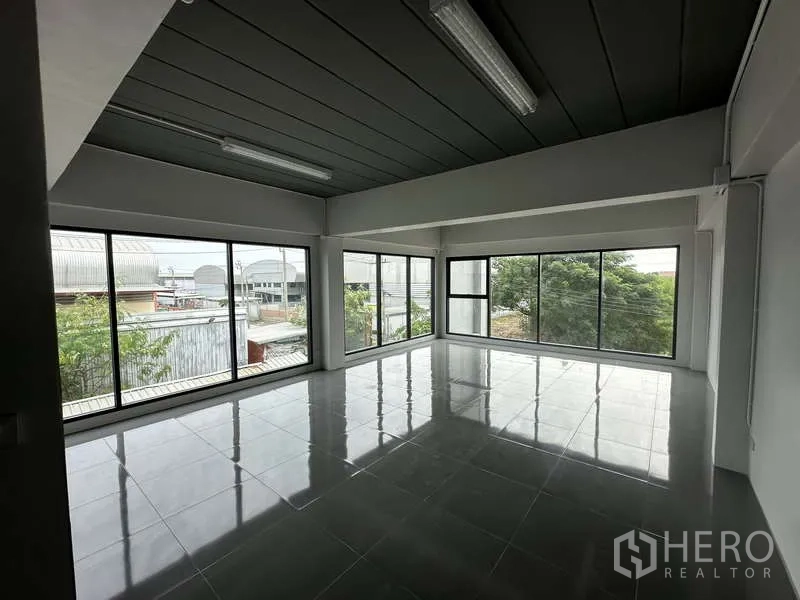 Factory for rent or sale in Bang Bua Thong, Nonthaburi - Corner office with floor-to-ceiling windows and green views.