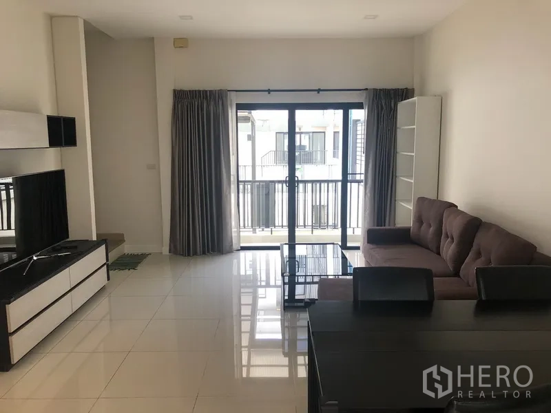ทาวน์เฮาส์ ให้เช่าในSaphan Sung, Bangkok - ห้องนั่งเล่นสว่างมีหน้าต่างบานใหญ่ พื้นกระเบื้องเงา และทางออกสู่ระเบียง