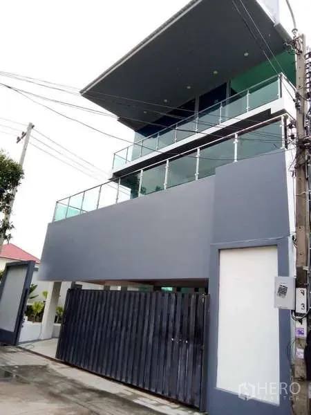独立式住宅 出售在Lat Phrao, Bangkok - 街景角度的三层现代住宅，带阳台与铁门。