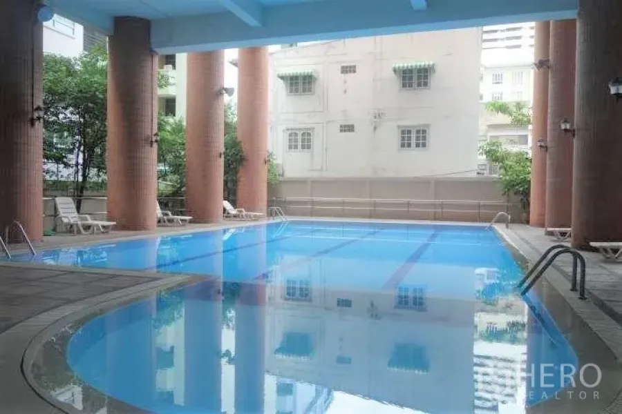 คอนโด ให้เช่าในWatthana, Bangkok - สระว่ายน้ำในร่มของคอนโด มีเสาสูงและเก้าอี้อาบแดด ย่านวัฒนา กรุงเทพฯ