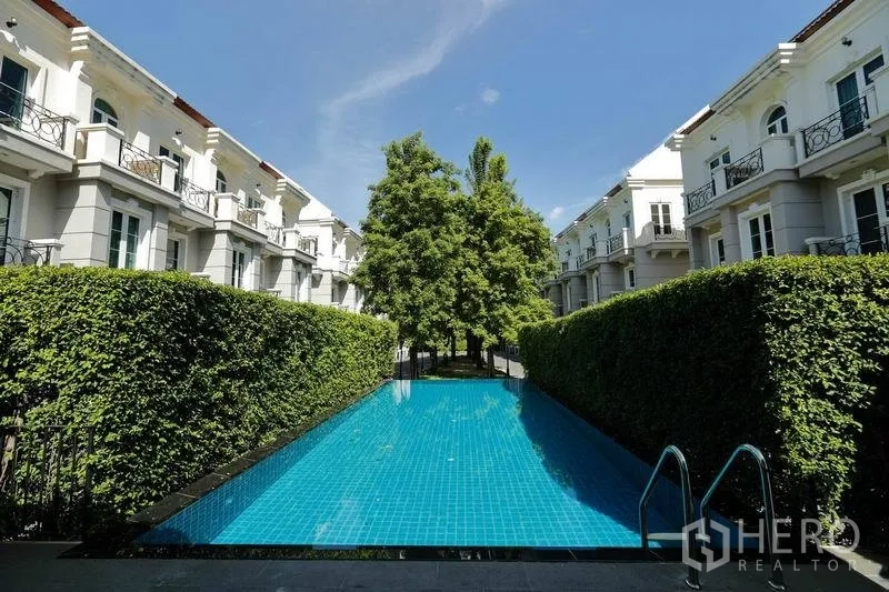 联排别墅 出租在Watthana, Bangkok - 社区共享泳池，被绿篱环绕