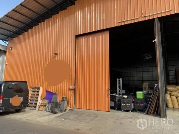 货栈 出租在Bang Kapi, Bangkok - 邦甲比橙色金属外立面仓库，设有大型推拉门与带顶装卸区。
