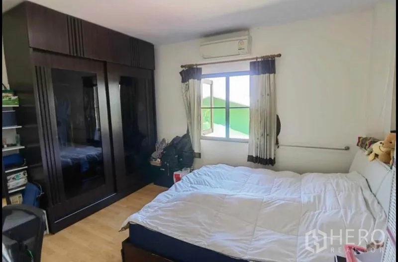 独立式住宅 出售在Bang Yai, Nonthaburi - 带空调的卧室，大床与深色嵌入式衣柜