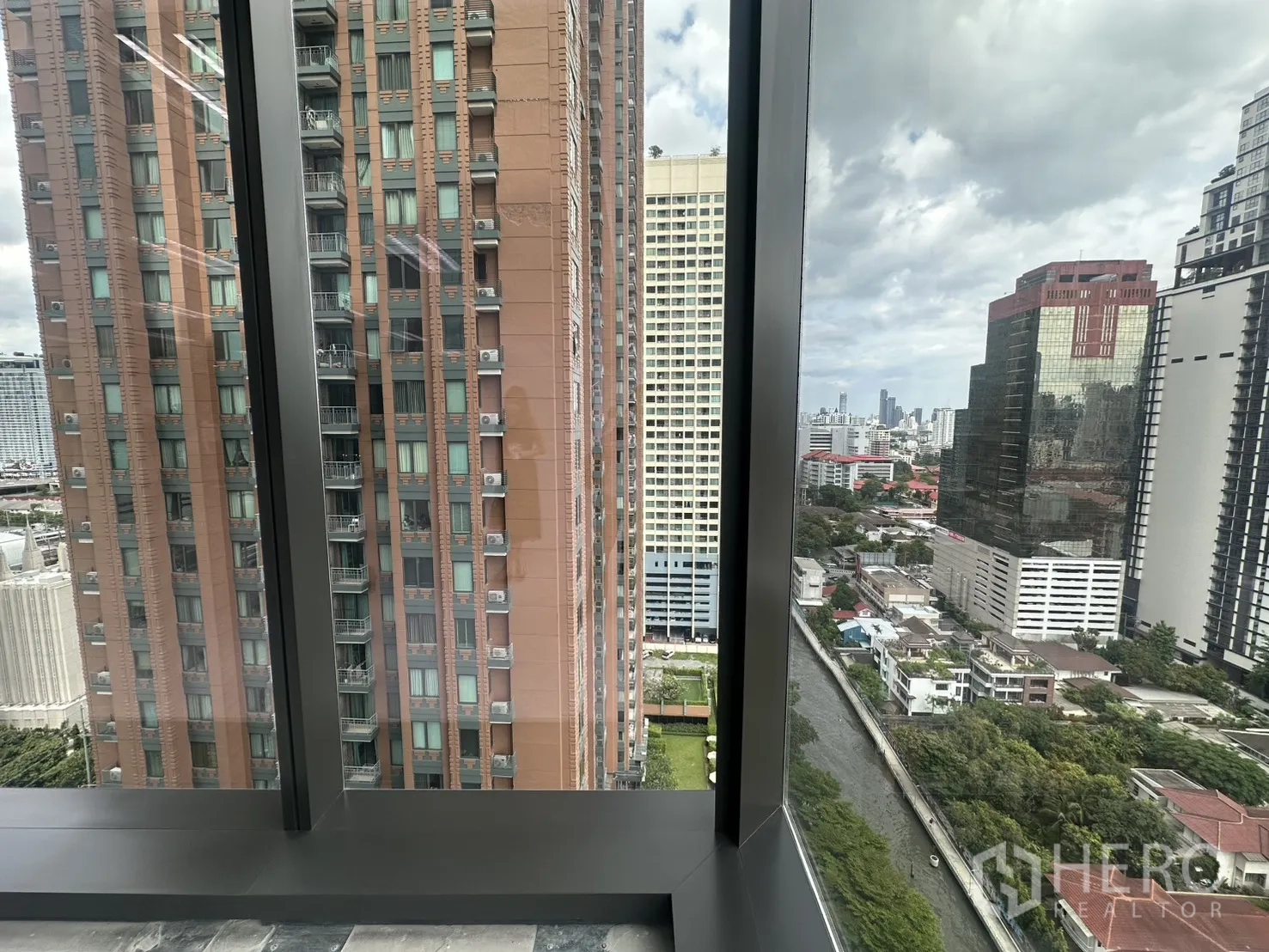 办公室 for rent in Ratchathewi, Bangkok - 从玻璃转角可见周边高楼与下方运河的城市景致。