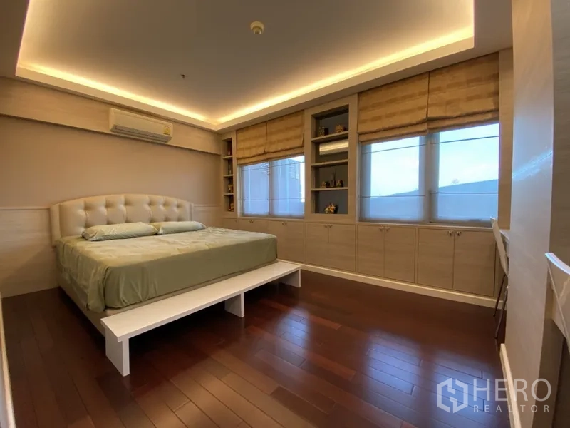 Condominium for rent in Bang Rak, Bangkok - Master bedroom with king bed, cove lighting, wide windows and extensive built-in storage.