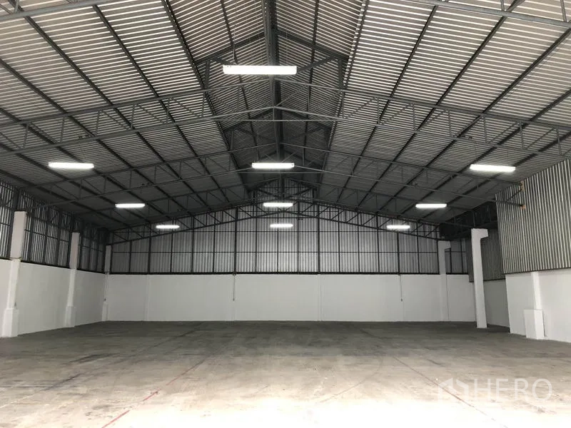 货栈 出租在Pak Kret, Nonthaburi - 仓库内部空间开阔，挑高钢结构屋顶与混凝土地面。