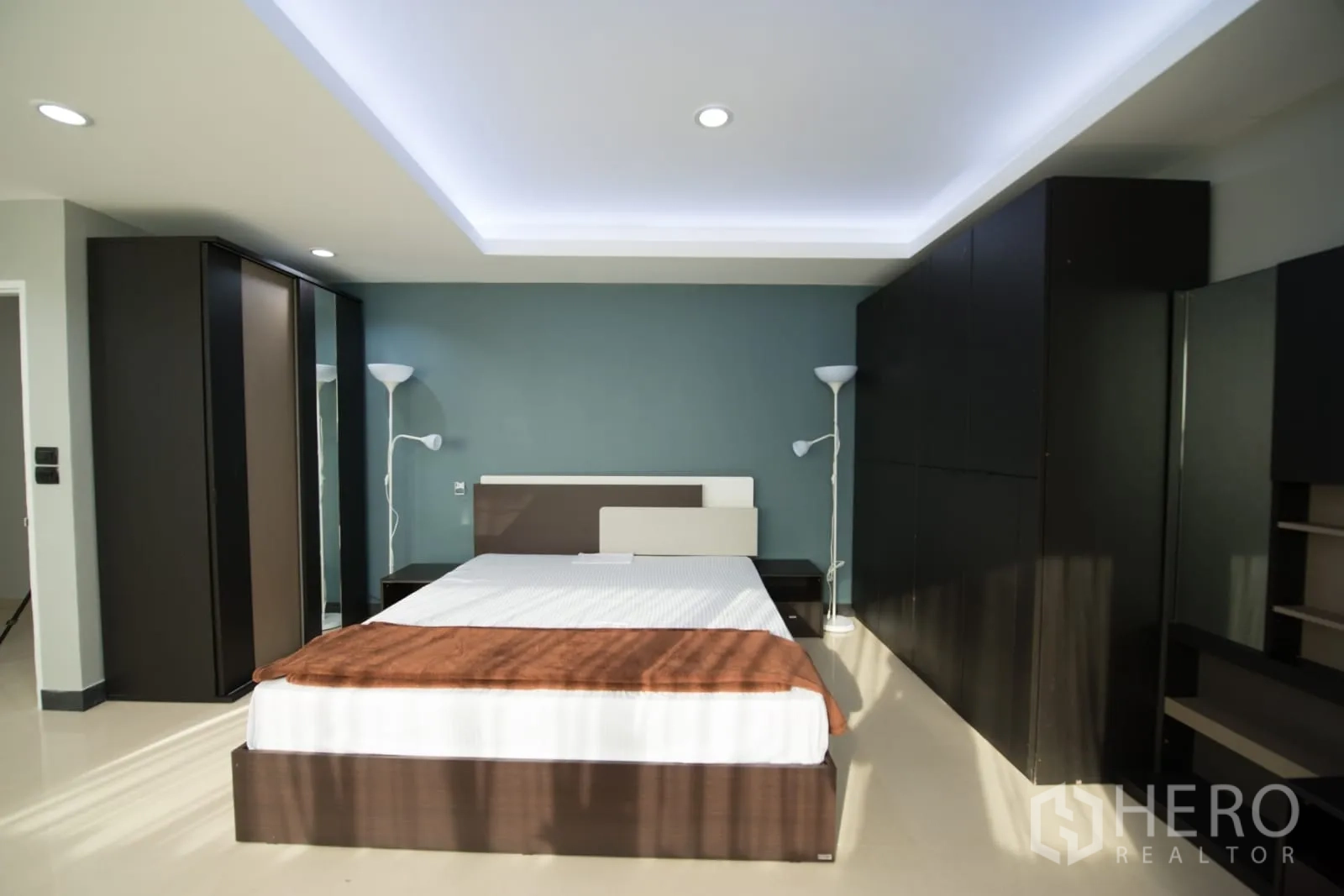 公寓 出租或出售在Khlong Toei, Bangkok - 主卧配托盘天花灯、蓝绿色重点墙、双人床与大衣柜。