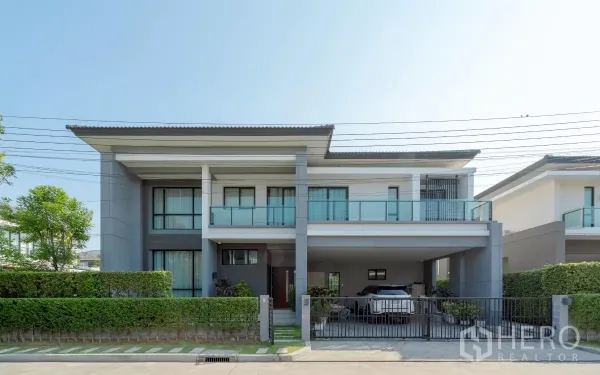 Detached House for sale in Saphan Sung, Bangkok - Modern two-storey detached house with gated carport and glass balcony in a secure estate.