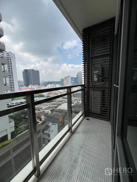 Condominium for rent in Khlong Toei, Bangkok - Side view from the balcony toward Bangkok skyline under partly cloudy skies.