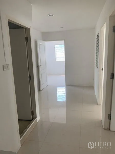 Townhouse for rent in Din Daeng, Bangkok - Bright ground-floor hallway with glossy tiled floors and white walls in Bangkok townhouse.