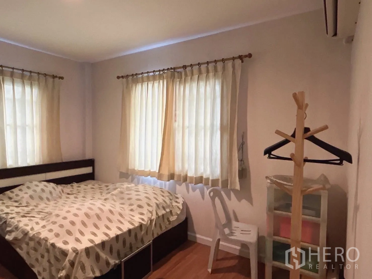 Detached House for sale in Bang Kapi, Bangkok - Ground-floor multipurpose room arranged as a bedroom with two corner windows.