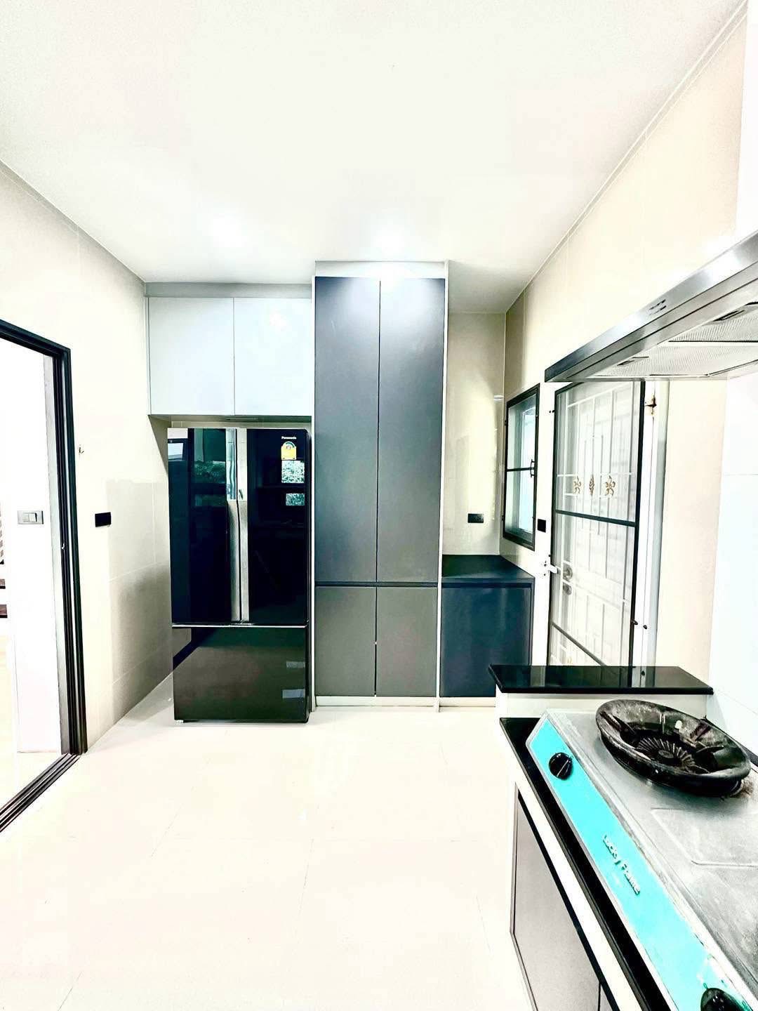 Detached House for rent in Bang Kapi, Bangkok - Bright kitchen with sleek tall cabinets and a double-door refrigerator.