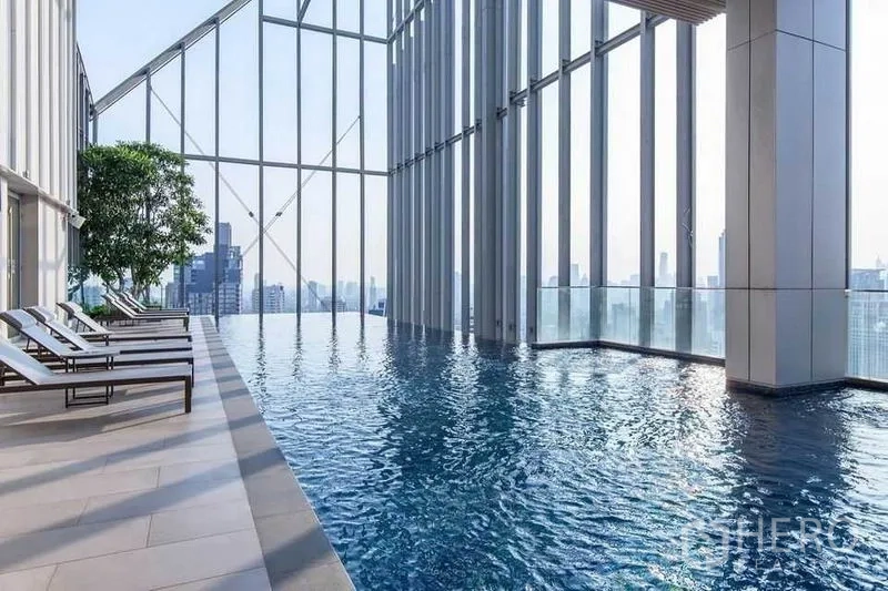 公寓 出售在Watthana, Bangkok - 天际线无边际泳池，设躺椅与高挑玻璃幕墙。