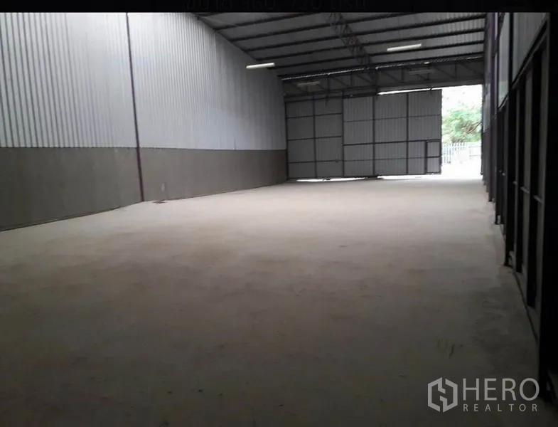 Warehouse for rent in Lam Luk Ka, Pathum Thani - Spacious warehouse interior with high steel truss roof, concrete floor and large entry doors.