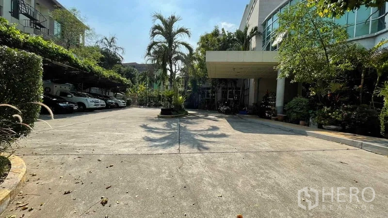 Warehouse for rent or sale in Bangkok Yai, Bangkok - Wide concrete driveway with covered drop-off and ample parking at the warehouse.