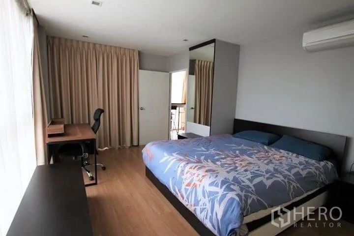 公寓 出租在Watthana, Bangkok - 主卧宽敞，配大床、书桌、落地窗帘与阳台门