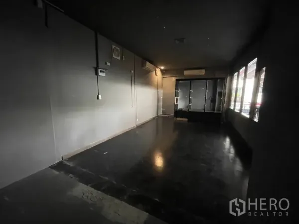 零售空间 出租 - 开放式店面，一侧整排窗户，后方玻璃展示柜，配多台空调。