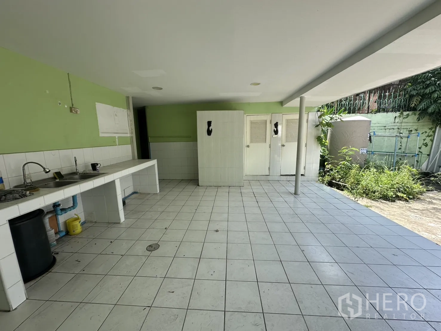 Retail Space for rent in Watthana, Bangkok - Covered outdoor service area with tiled floor, sink and storage doors.