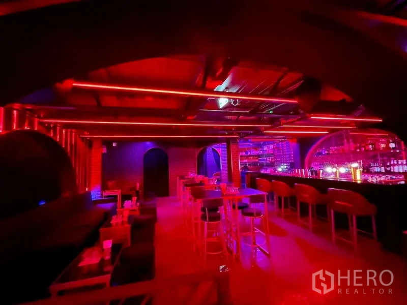 Retail Space for rent in Bangkok - Open bar hall with high tables, arched back bar and red ceiling lights.