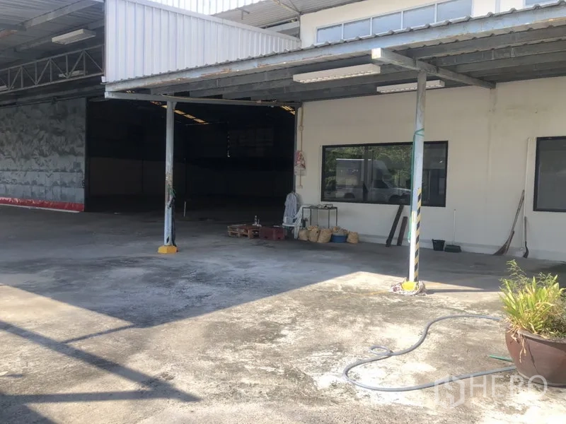 Warehouse for rent in Prawet, Bangkok - Front yard with canopy roof, warehouse entrance and exterior windows for natural light.