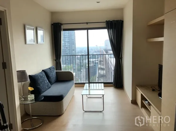 Condominium for rent in Khlong Toei, Bangkok - Bright living room with sofa, TV console and glass coffee table opening to a city-view balcony in a Khlong Toei condo near BTS Thonglor.