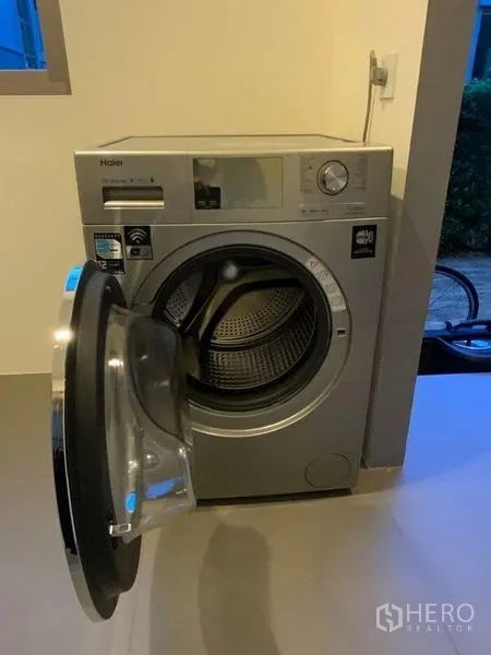 Townhouse for rent in Prawet, Bangkok - Front-loading washing machine in the laundry area.