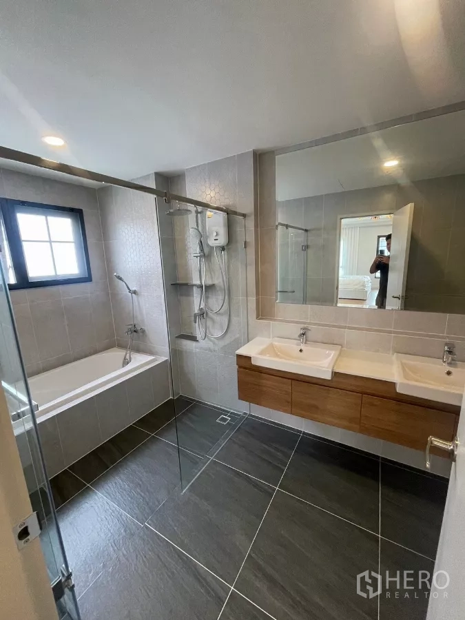 Detached House for rent in Bang Phli, Samut Prakan - Modern bathroom with bathtub, glass shower enclosure and double vanity.