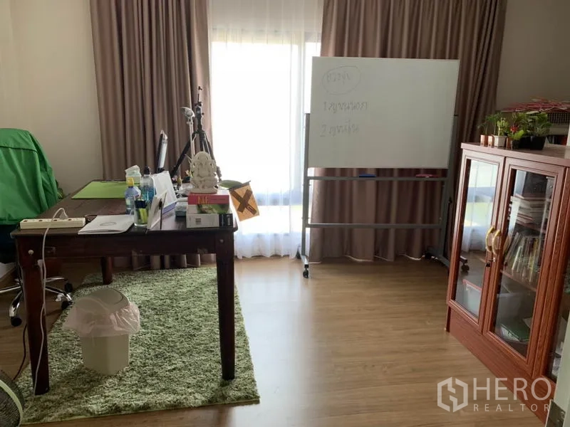 Detached House for rent or sale in Samut Prakan - Multi-purpose study room with desk, cabinet and full-height curtains to a balcony.