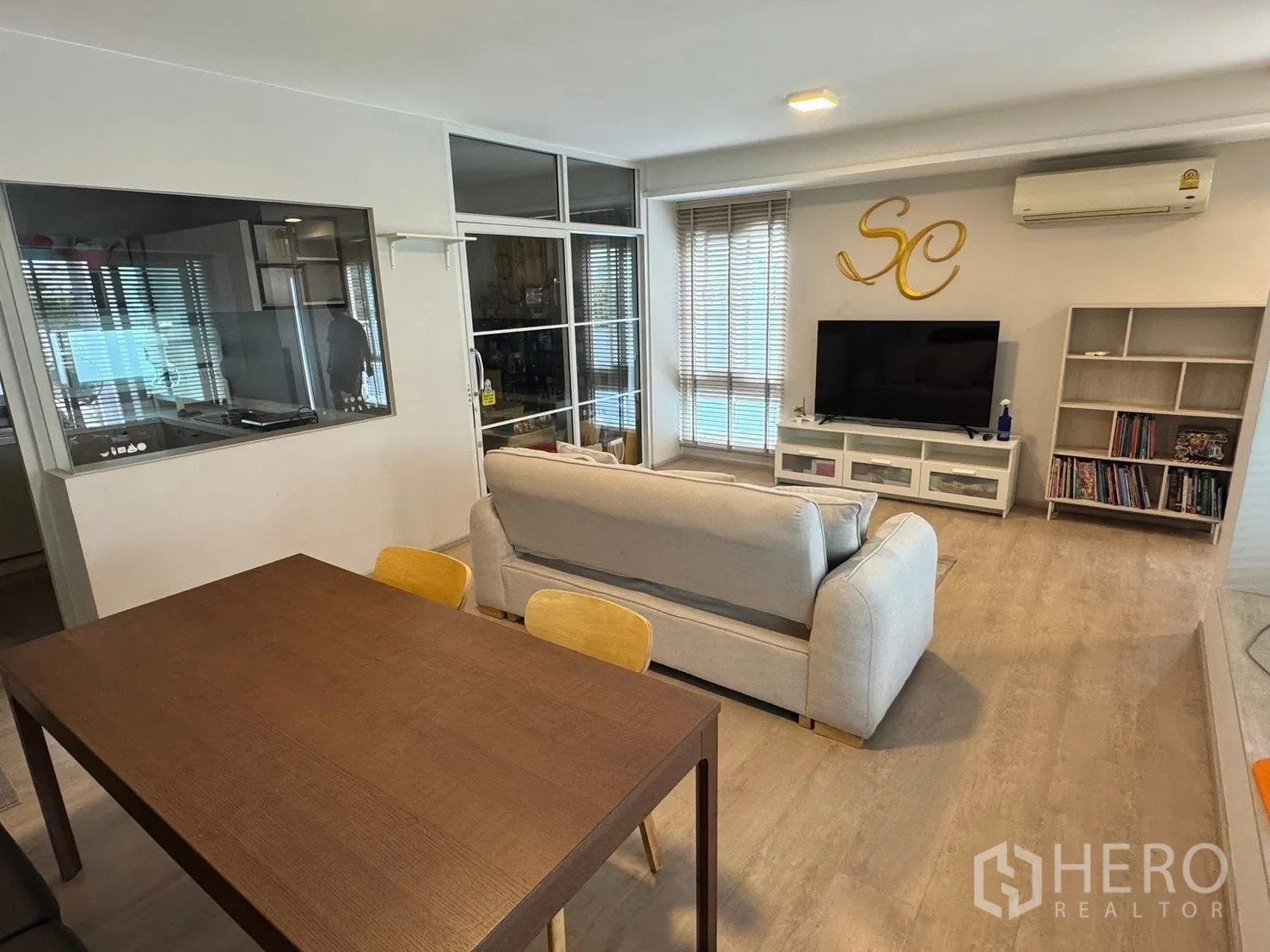 半独立式住宅 for rent in Prawet, Bangkok - 开放式客餐厅，沙发、电视柜、餐桌及玻璃隔断厨房。