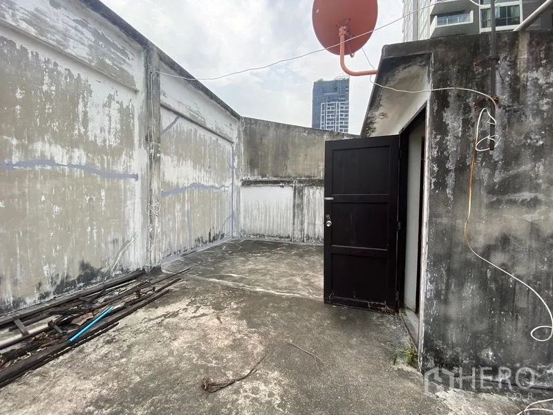 Retail Space for rent in Watthana, Bangkok - Rooftop terrace with concrete floor and satellite dish, with high-rise backdrop.