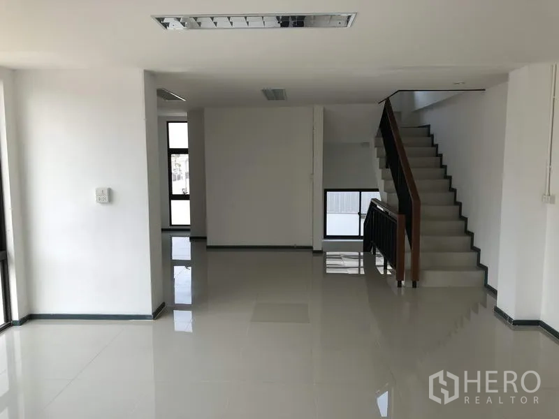 Factory for rent or sale in Pathum Thani - Open-plan office with tiled floors and staircase to upper level.