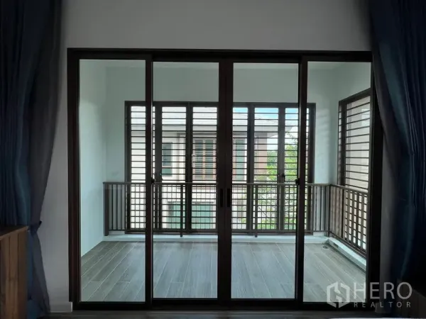 Detached House for rent in Bang Kapi, Bangkok - Enclosed balcony or sunroom with sliding glass and wooden louver screens.