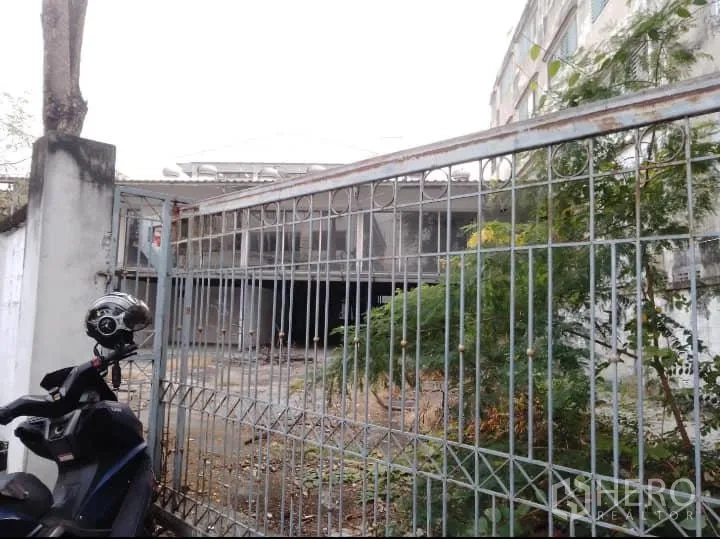 Warehouse for rent or sale in Bang Kho Laem, Bangkok - Gated entrance with metal fence and a motorcycle in front of a two-storey warehouse yard.