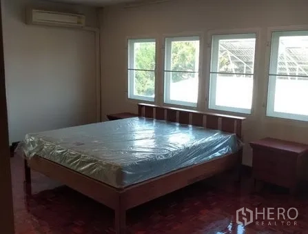 Apartment for rent in Pathum Wan, Bangkok - Spacious bedroom with double bed, side tables, multiple windows and air conditioning.