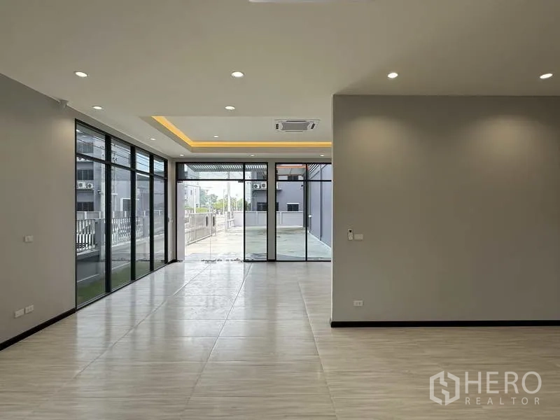 Factory for rent or sale in Lam Luk Ka, Pathum Thani - Ground-floor office with floor-to-ceiling glass, recessed lighting and tiled floors.
