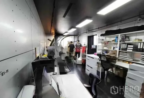 Shophouse for rent in Khlong Toei, Bangkok - Back-of-house workspace with desks, shelving and bright ceiling lights.