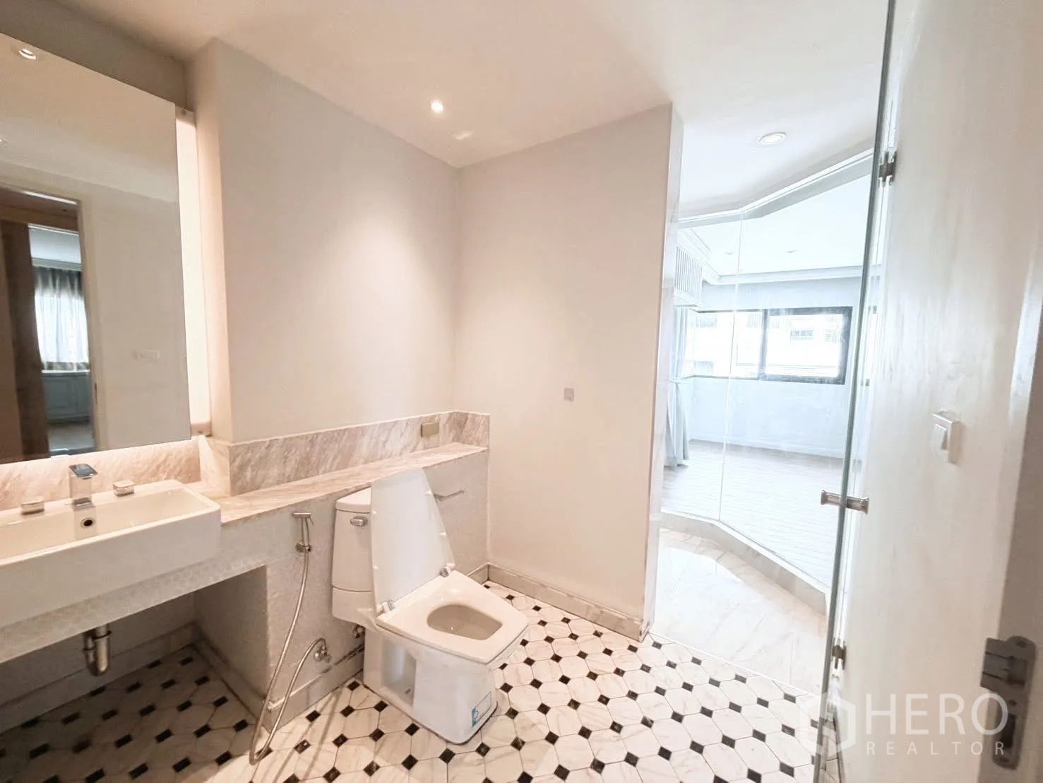 Condominium for rent or sale in Sathon, Bangkok - Spacious bathroom with vanity and black-and-white patterned floor tiles.