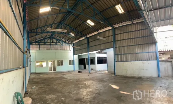 Warehouse for rent or sale in Bang Na, Bangkok - Open-plan warehouse interior with high steel trusses, concrete floor and ample lighting.