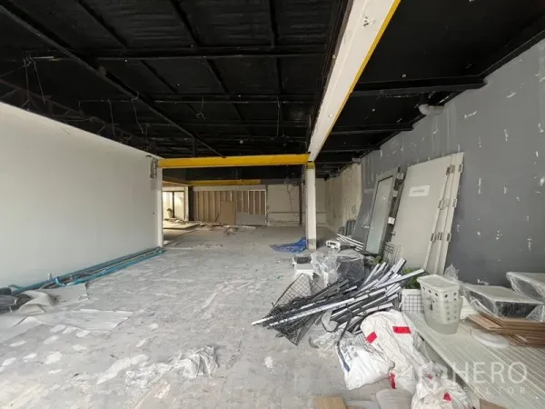 Retail Space for rent in Watthana, Bangkok - Open-plan retail interior under renovation with black ceiling, yellow beams and concrete floor.